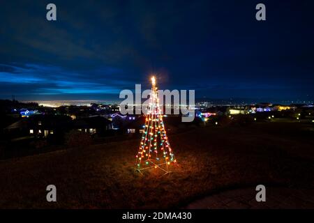 Ein beleuchtetes Weihnachtsschmuck sitzt auf einem Hügel Terrasse mit Blick auf das Spokane Valley und die Innenstadt in Washington State, USA Stockfoto