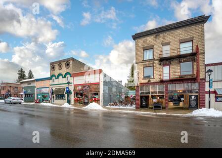 Die Hauptstraße der historischen kleinen Holzstadt Spirit Lake in den Bergen von Nord-Idaho während der Winterschneesaison. Stockfoto