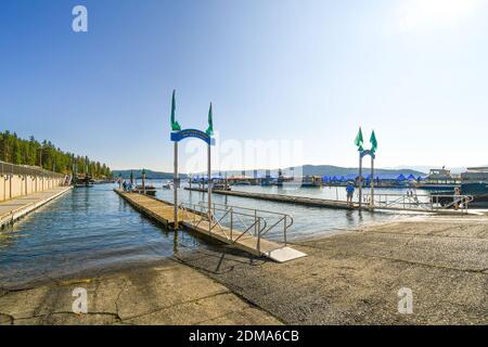 Bootsfahrer genießen einen sonnigen Tag an der Bootsanlegestelle Lake Coeur d'Alene, dem Yachthafen und dem Dock im Inland im Nordwesten der USA. Stockfoto