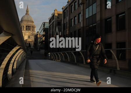 London, Großbritannien. Dezember 2020. Eine Person geht auf der Millennium Bridge bei Sonnenaufgang in London, Großbritannien, am 16. Dezember 2020. Ab Mittwoch Mitternacht zog London in die dritte Stufe, die höchste Stufe in Englands lokalem Coronavirus-RestriktionsTier-System. Quelle: Tim Ireland/Xinhua/Alamy Live News Stockfoto