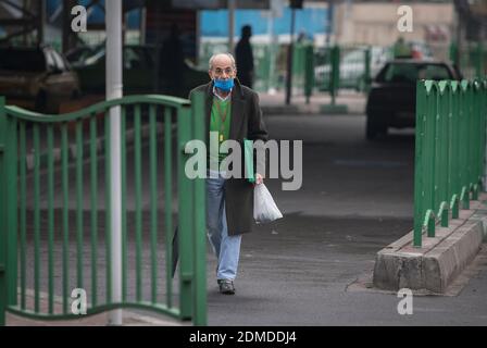 Teheran, Iran. Dezember 2020. Ein Mann mit Gesichtsmaske geht auf einer Straße in Teheran, Iran, 16. Dezember 2020. Das iranische Gesundheitsministerium meldete 7,603 neue COVID-19 Fälle, was die Gesamtzahl der Infektionen auf 1,131,077 erhöht. Sie meldete auch 213 neue Todesfälle, was die Zahl der Todesopfer auf 52,883 besagte. Quelle: Ahmad Halabisaz/Xinhua/Alamy Live News Stockfoto