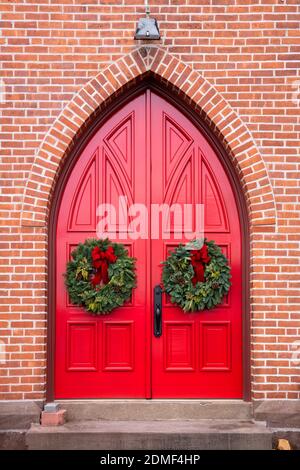 Rote Türen mit Kränzen zu Weihnachten, St. Peters Episcopal Church, Connecticut Stockfoto