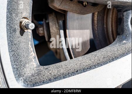 Durchführung einer Wartungsprüfung an einem Fahrzeugreifen durch Druckprüfung Stockfoto