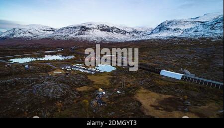 Aerial drone shot of a train and railway station, in a Riksgransen town, snowy, fall day, in Lappland, Norrbotten, North Sweden Stock Photo