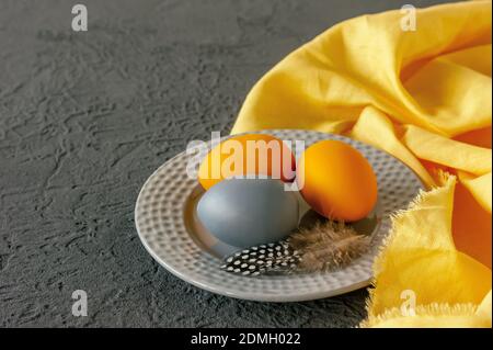 Ostern consept in trendigen Farben leuchtend gelb und ultimative grau. Bemalte Eier auf einem Teller mit Copyspace. Stockfoto