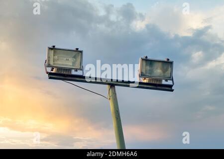 Set aus zwei Outdoor-Flutlicht und eine Stange für Sportstadion, Parkplatz oder öffentlichen Park Beleuchtung gegen schönen Sonnenuntergang Himmel und Wolken backgr Stockfoto