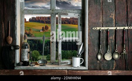 rustic farmer's kitchen with a view of the landscape through a wooden window Stock Photo