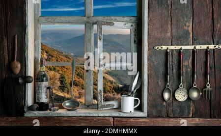 rustic farmer's kitchen with a view of the landscape through a wooden window Stock Photo