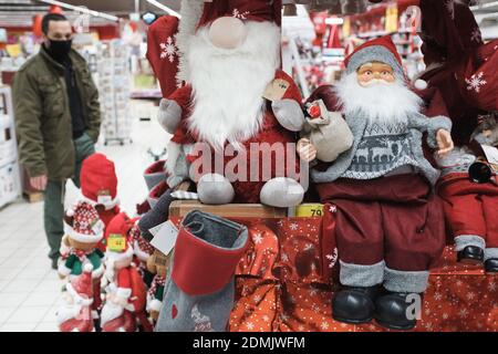 BRESLAU, POLEN - 27. NOVEMBER 2020. Weihnachtsdekoration im Supermarkt und Mann mit Gesichtsmaske im Hintergrund. Wegen Coronavirus Pandemie Cov Stockfoto