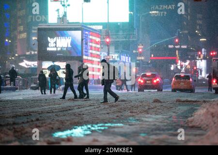 New York, USA. Dezember 2020. Fußgänger gehen am Times Square in New York, USA, 16. Dezember 2020. Ein Schneesturm traf New York am Mittwoch. Quelle: Wang Ying/Xinhua/Alamy Live News Stockfoto