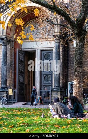 Berlin, Mitte, Zionskirche, zwei junge Künstler, die auf Gras vor der Zionskirche sitzen. Künstler bei der Arbeit Stockfoto