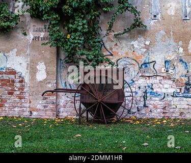 Der Aedes Netzwerk Campus Berlin, ANCB Hof und Freifläche, Christeninstraße, Prenzlauerberg, Berlin. Rostige Schubkarre & getherte Wand der AE Stockfoto