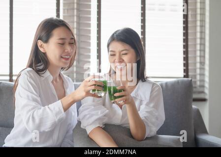 Two beautiful woman enjoy drinking healthy drink during stay safe at home Stock Photo