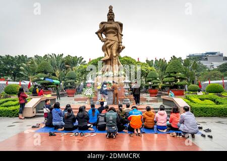 Hai Phong Stadt, Vietnam - 15. November 2020: Eine Gebetsstunde unter der Statue eines Nationalhelden auf einem Platz in Hai Phong Stadt Vietnam Stockfoto