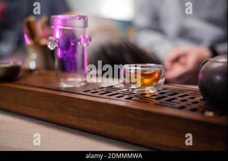 Glas Tasse und Flasche für Tee auf einem Bambusbrett mit einem Tablett. Nahaufnahme der Teezeremonie auf dem Tisch Stockfoto