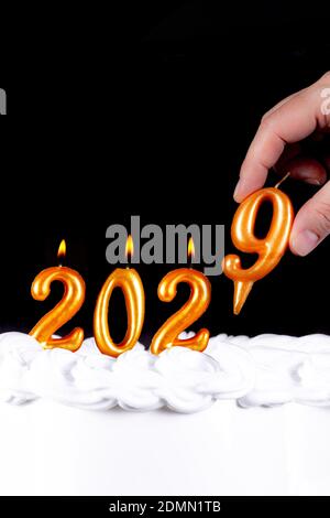 Four golden candles write numbers flame happy new year 2029 hand black background Stock Photo