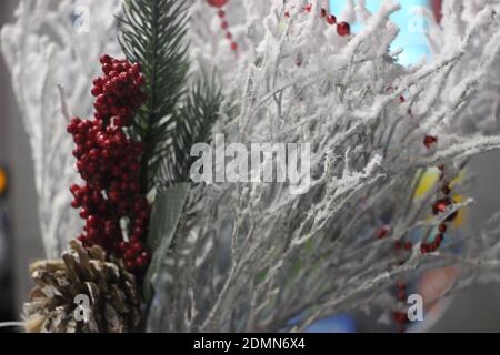 Weihnachtsdekoration. Weiße verschneite Äste, rote Beeren und weihnachtsbaum. Stockfoto