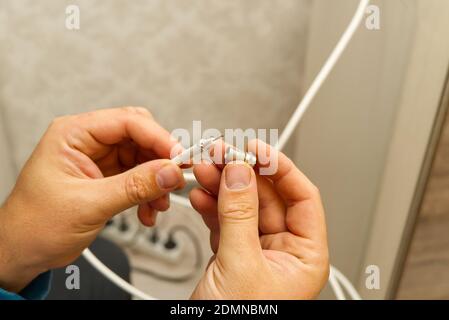 Elektriker anschließen der Kabel der TV-Antenne während der Renovierung des Hauses. Master Montage TV-Kabel Stockfoto