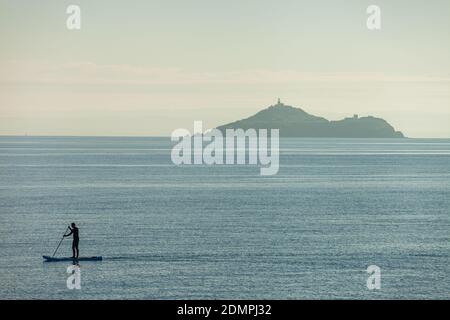 Ein Paddelboarder vor Inchkeith Island vom Kinghorn Harbour aus gesehen, Fife, Schottland. Stockfoto