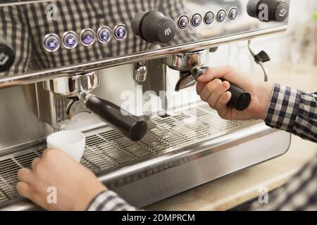 Nahaufnahme eines professionellen Barista mit einer Kaffeemaschine Während der Arbeit in seinem Café Getränke für Kunden Ausrüstung vorzubereiten Beruf kleine busi Stockfoto