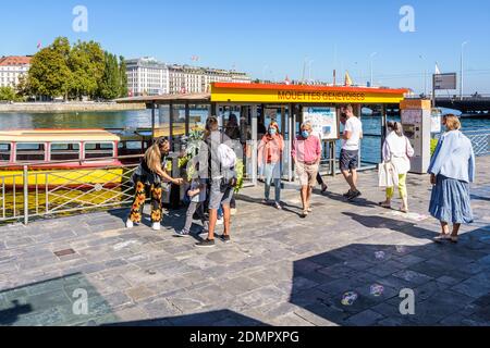 Menschen stehen an Bord eines Wasserbusses, während Passagiere in Genf aussteigen. Stockfoto