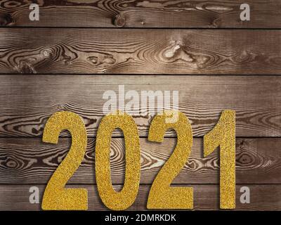 2021 goldene Figuren strukturiert mit Glitzern auf einer rustikalen Planke Stockfoto