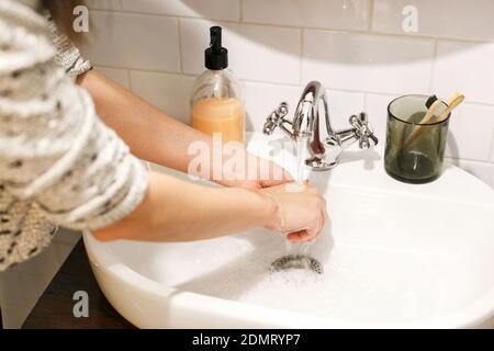 Hände waschen. Hände waschen mit der richtigen Technik und antibakterielle Seife auf dem Hintergrund von fließendem Wasser im Badezimmer. Reiben der Finger. Corona verhindern Stockfoto
