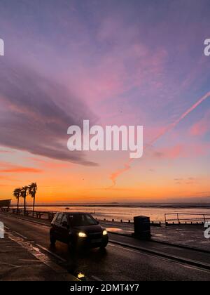 Fantastische Farben im Pre-Sunrise Sky über der Themse Mündung AS Gesehen von der Küste in Westcliff-on-Sea an einem Dezembermorgen mit Auto im Vordergrund Stockfoto