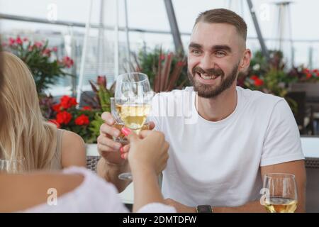 Schöner junger Mann klinkende Gläser mit seine Freundin während auf Ein Date im Dachrestaurant Stockfoto