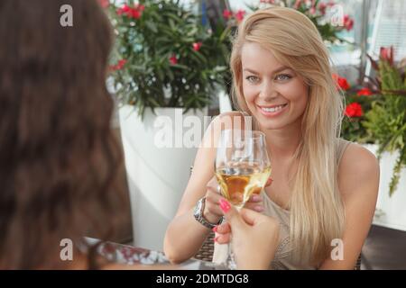 Schöne glückliche Frau klirren Gläser mit ihrer Freundin, genießen Wein an der Bar trinken Stockfoto
