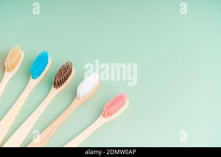 Ein Set umweltfreundlicher antibakterieller Zahnbürsten aus Bambusholz auf hellgrünem Hintergrund. Trends im Bereich Umweltschutz. Stockfoto