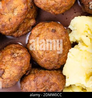 Draufsicht auf gekochte schwedische Fleischbällchen mit Preiselbeersoße und Kartoffelpüree aus nächster Nähe Stockfoto