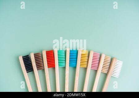 Ein Set umweltfreundlicher antibakterieller Zahnbürsten aus Bambusholz auf hellgrünem Hintergrund. Trends im Bereich Umweltschutz. Stockfoto