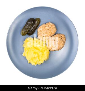 Von oben aus hat man einen Blick auf die servierte Portion hausgemachten, gedämpften roten Fisch Koteletts und Kartoffelpüree auf blauem Teller isoliert auf weiß Hintergrund Stockfoto