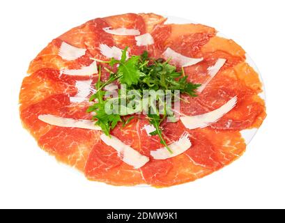 Portion Carpaccio (dünn geschnittenes Roh-Rinderfilet) verziert von Parmesan, Arugula auf weißem Teller isoliert auf weißem Hintergrund Stockfoto