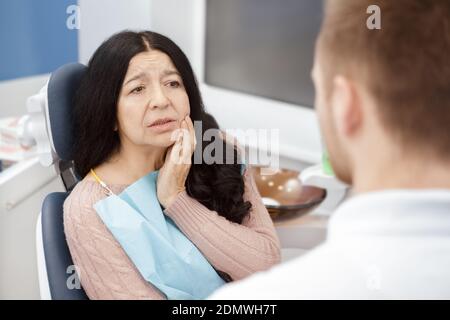 Dieser Schmerz ist unerträglich! Ältere weibliche Patientin besucht professionelle Zahnarzt Zahnschmerzen suchen verzweifelt und verärgert Schmerzen Schmerzen p Stockfoto