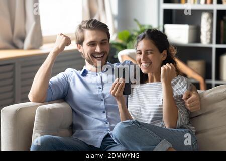 Overjoyed couple celebrate good message on cellphone Stock Photo