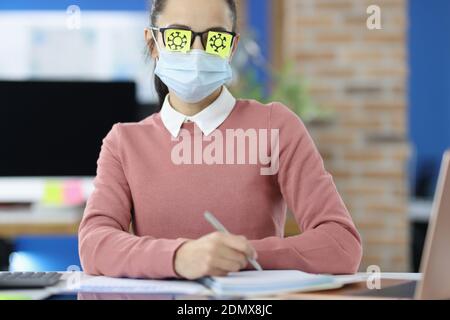 Porträt der Geschäftsfrau in medizinische Schutzmaske und Aufkleber auf Die Brille Stockfoto