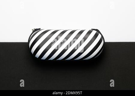 Gestreiftes Brillen-Etui isoliert auf einem schwarz-weißen Hintergrund Stockfoto