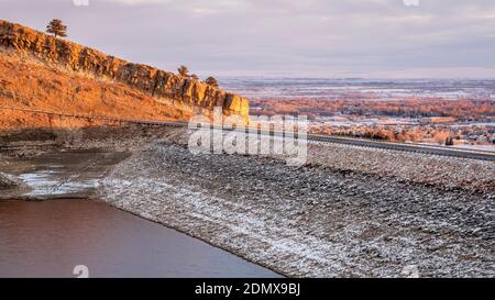 sunrise light over Horsetooth Reservoir, dam and city of Fort Collins - winter scenery with a low water level Stock Photo