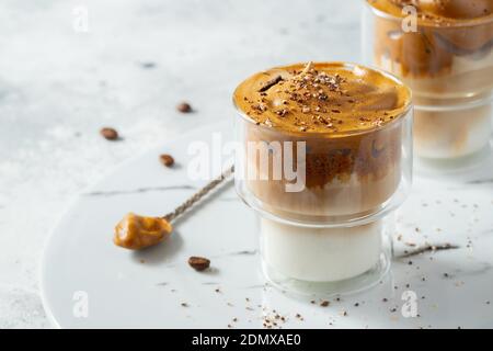 Dalgona Kaffee. Iced flauschig cremig Schlagtrend Drink mit Kaffee Schaum und Milch. Trendiges Getränk während der Stadtsperre Covid-19 und der Selbstquarantäne Stockfoto