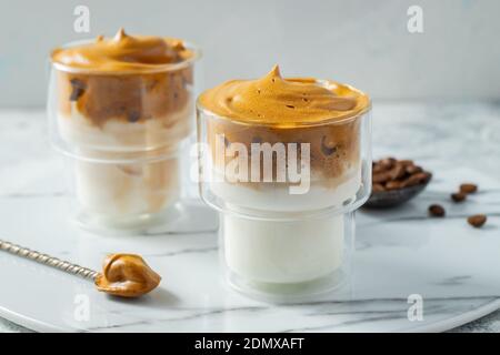 Dalgona Kaffee. Iced flauschig cremig Schlagtrend Drink mit Kaffee Schaum und Milch. Trendiges Getränk während der Stadtsperre Covid-19 und der Selbstquarantäne Stockfoto