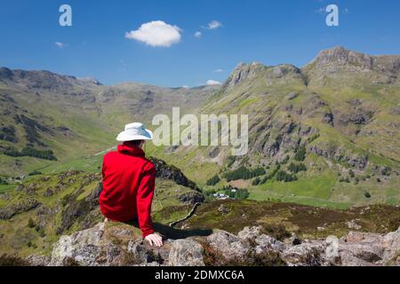 Great Langdale, Cumbria, England. Wanderer mit Blick auf Mickleden und die Langdale Pikes vom felsigen Gipfel des Lingmoor Fell. Stockfoto