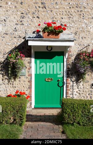 East Dean, East Sussex, England. Helle grüne Tür eines typischen Dorfhauses. Stockfoto
