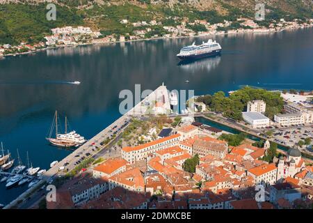 Kotor, Montenegro. Blick über die Altstadt und die Bucht von Kotor von der Stadtmauer, das Kreuzfahrtschiff Azamara Reise nähert. Stockfoto