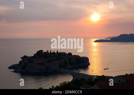 Sveti Stefan, Budva, Montenegro. Blick über das ruhige Wasser der Budva Bucht und das exklusive Inselresort Sveti Stefan, Sonnenuntergang. Stockfoto