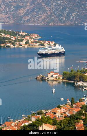 Kotor, Montenegro. Blick über die Bucht von Kotor von der Stadtmauer, das Kreuzfahrtschiff Azamara Reise vorbei vor dem Dorf Prčanj. Stockfoto