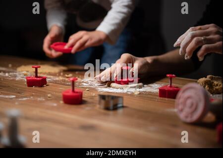 Mutter und Kind machen auf Holzschreibtisch vegane Kekse. Stockfoto