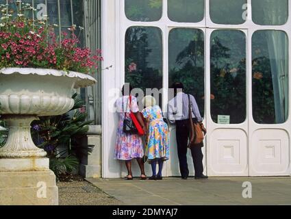 afro-karibische Besucher außerhalb des Gewächshauses in den Kew Gardens, Surrey, England Stockfoto