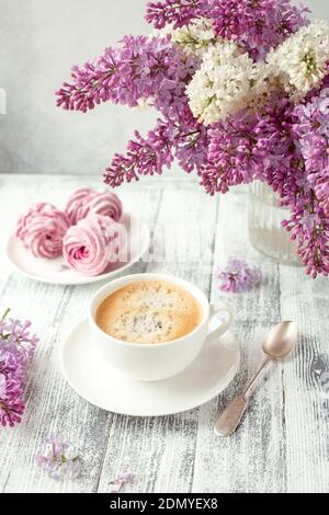 Cup of coffee, homemade marshmallow, lilac flowers. Romantic spring morning Selective focus - Image Stockfoto